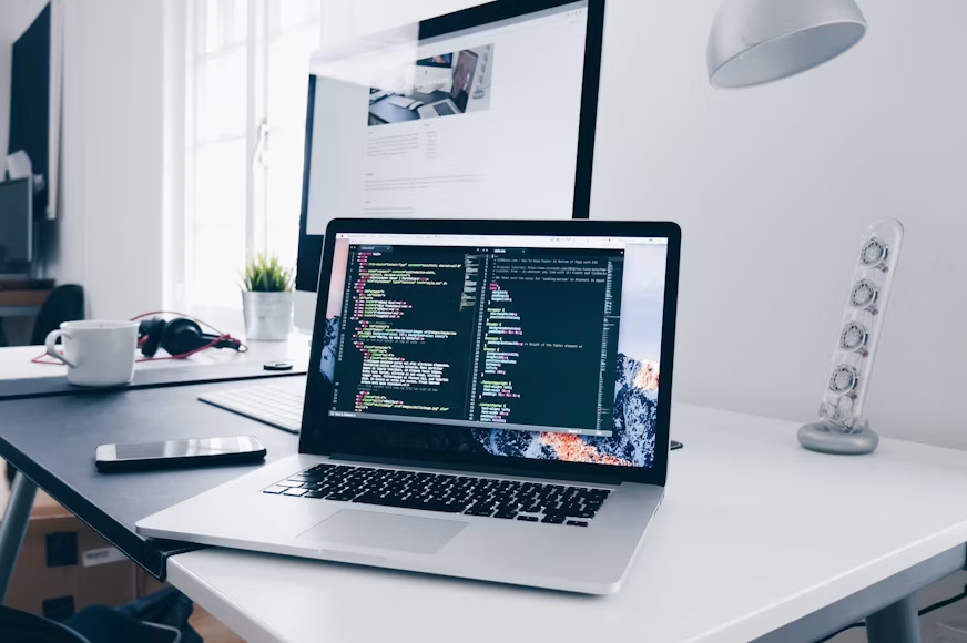 Laptop open to a code editor on a desk